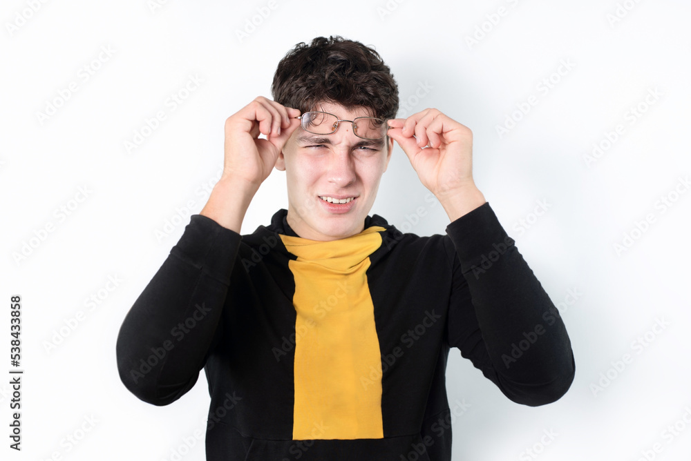 Φωτογραφία Young teenager boy has poor vision, wears glasses, now removed glasses and squints to focus on object, medical concept
