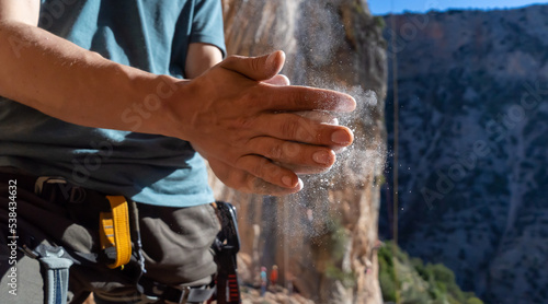 Man climbs with magnesium powder, hands closeup.