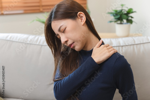 фотографія Asian woman feeling hurt shoulder and neck muscle problem.