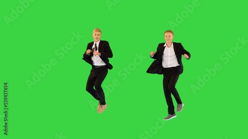 Two good-looking office workers perform charleston dance on a Green Screen, Chroma Key. photo