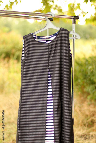 A black and white striped dress hangs on a hanger.
