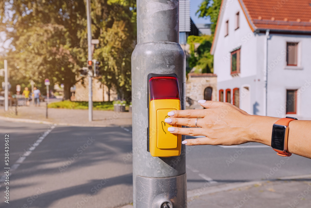 Aware passenger presses the traffic light control button to safely cross the street. Accident reduction rules