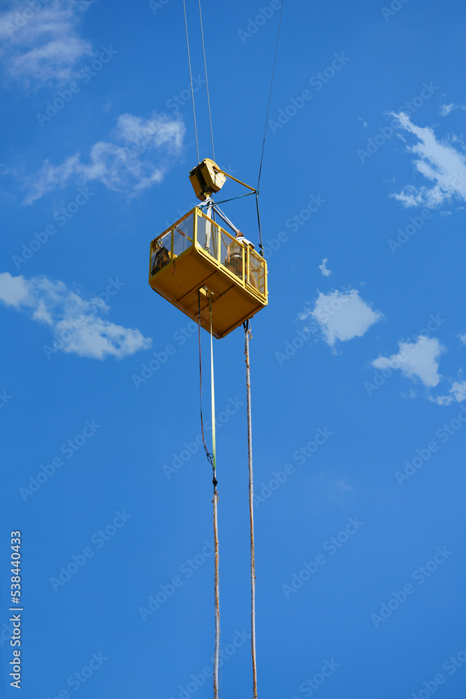 An extreme sportsman jumps on a rope from a crane. bungee jump in sunny day. Ropejumping.