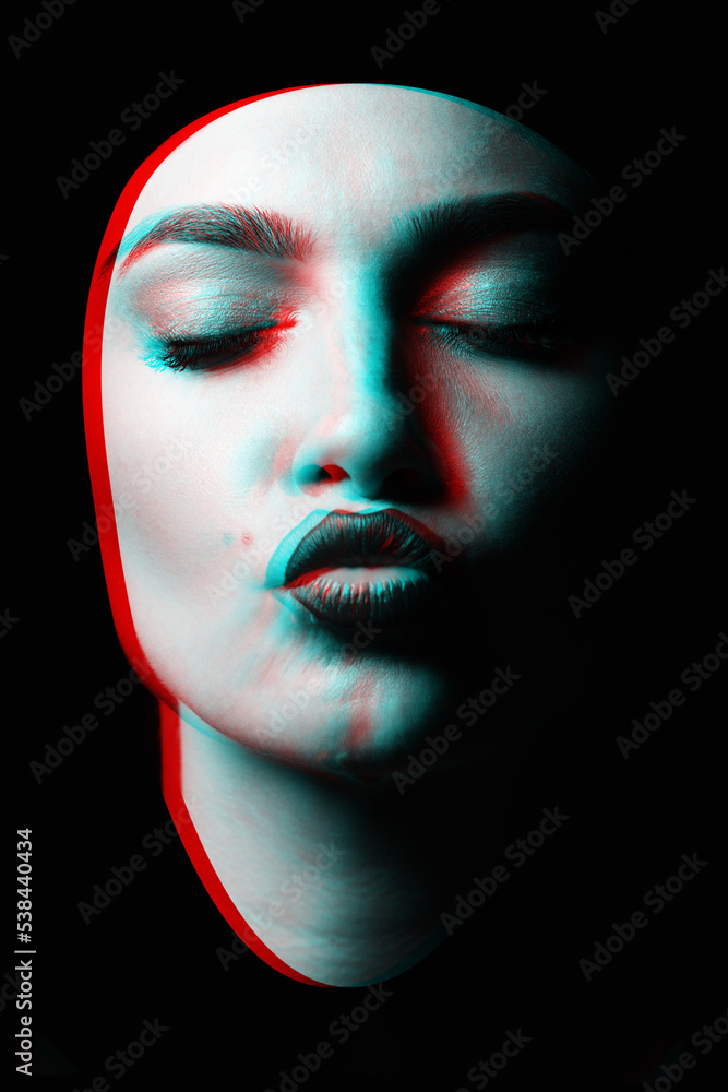 Beauty, fashion and make-up concept. Portrait of a young and beautiful woman with closed eyes sending kiss isolated over black background in red and blue color split effect. Futuristic looking style Beauty, fashion and make-up concept. Portrait of a young and beautiful woman with closed eyes sending kiss isolated over black background in red and blue color split effect. Futuristic looking style