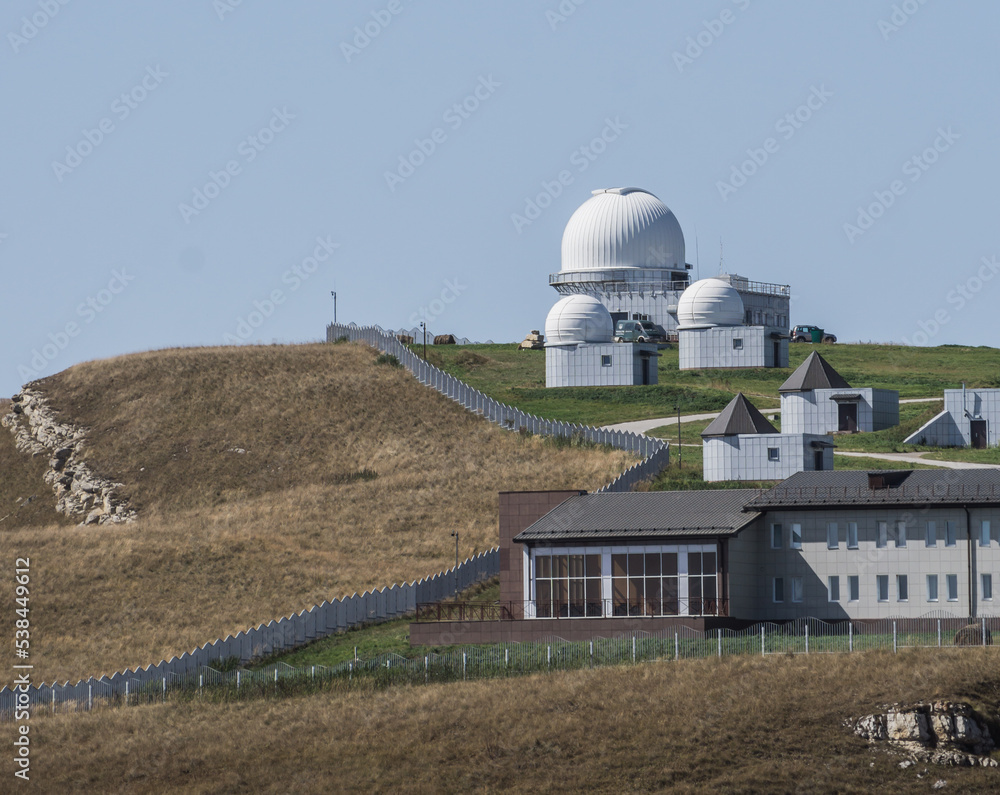 Astronomical observatory in the Caucasus mountains with a territory for research on a mountain hill, on a warm October day in autumn Astronomical observatory in the Caucasus mountains with a territory for research on a mountain hill, on a warm October day in autumn