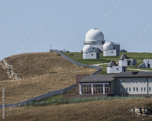 Astronomical observatory in the Caucasus mountains with a territory for research on a mountain hill, on a warm October day in autumn