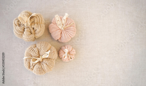 Hobby background with handmade knit pumpkins. DIY, craft decoration for fall and winter holidays. Flat lay, top view