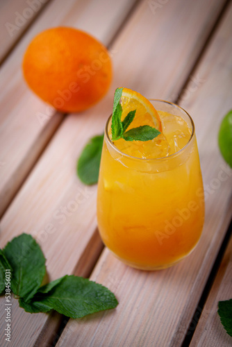 Alcoholic refreshing cocktail with orange, passion fruit and ice cubes, on the summer terrace of the restaurant