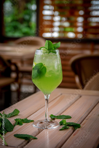Alcoholic refreshing cocktail Hugo Spritz with ice cubes, on the summer terrace of the restaurant. Summer Italian aperitif made with Prosecco sparkling wine, lime, mint and elderflowers syrup