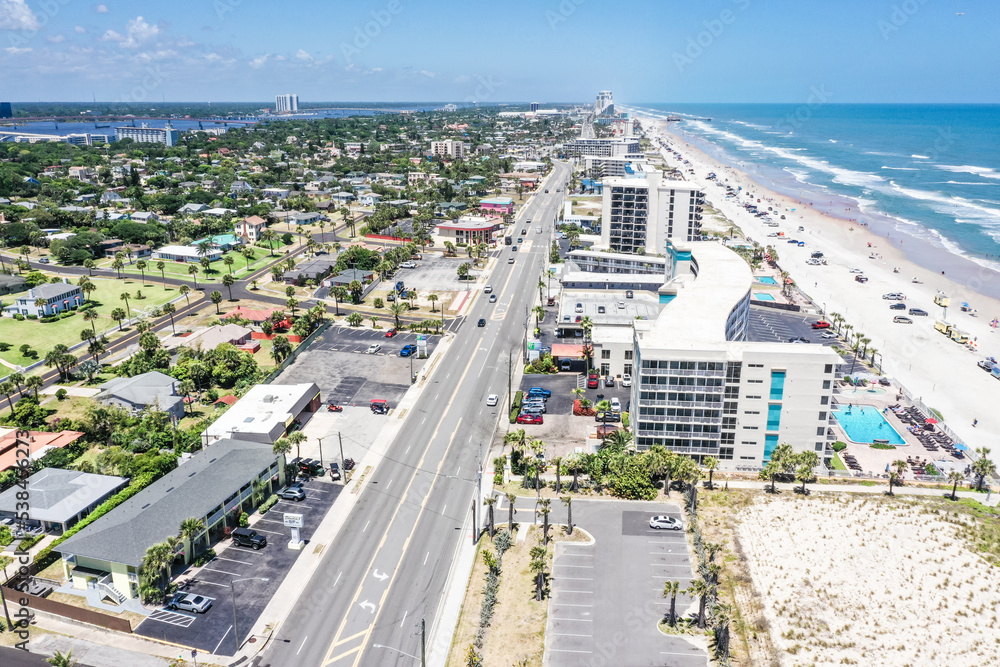 Aerial looking north over Daytona Beach, Florida neighborhoods, beachfront hotels and condos and the Atlantic Ocean on the right and the Intracoastal Waterway on the left.