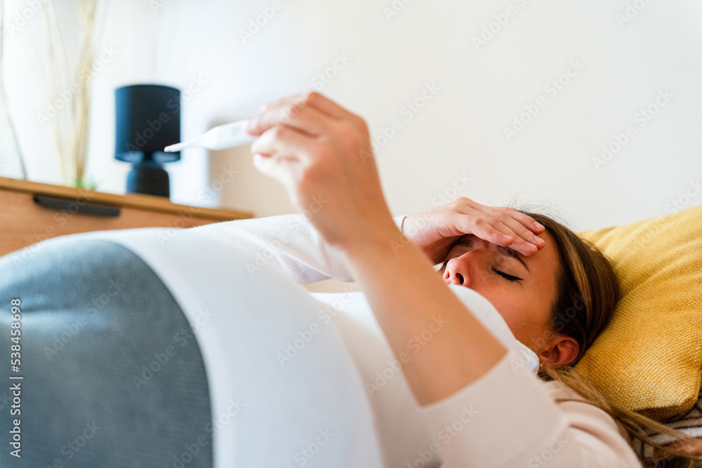 Pregnant temperature fever check. Pregnancy woman holding thermometer