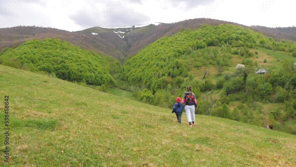 Following A Woman And A Kid Walking Along A Mountain Slope Following A Woman And A Kid Walking Along A Mountain Slope