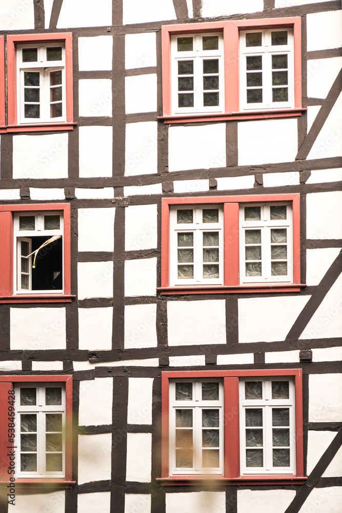 Fachwerk, altes Haus in Deutschland, Holz, antiker Holzbau, rote Fenster, Sprossen