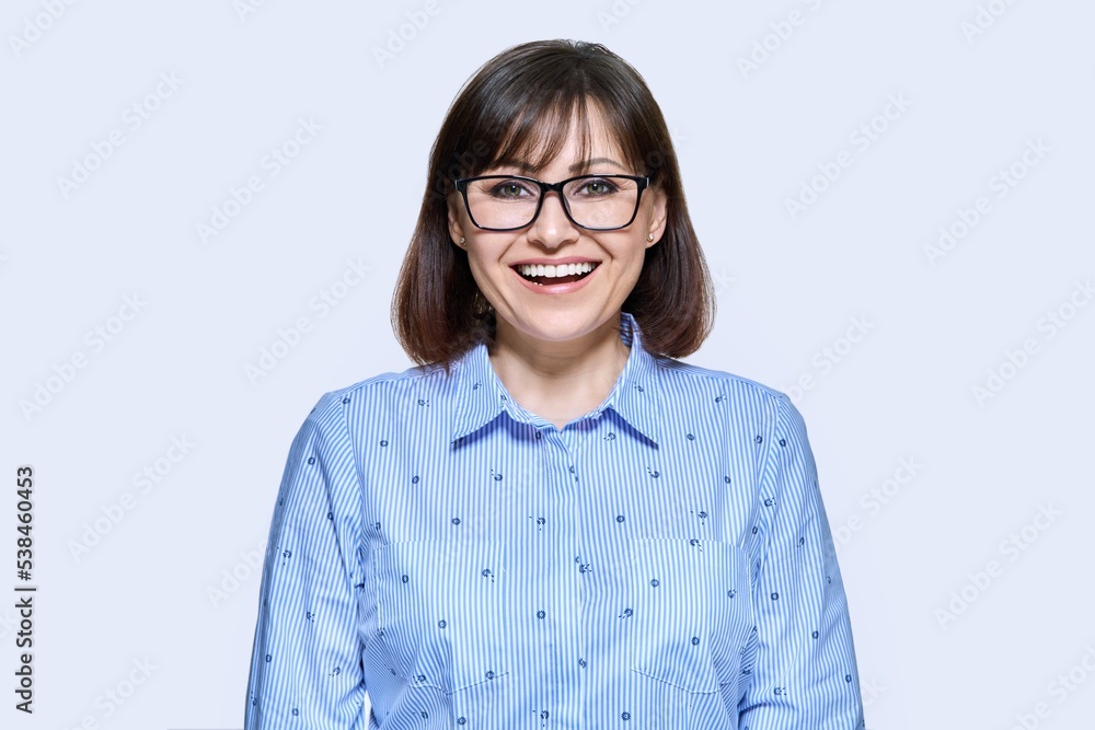 Middle aged smiling business woman over light background Middle aged smiling business woman over light background