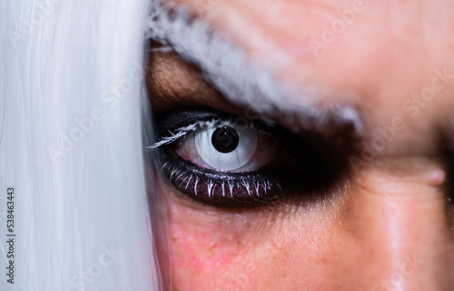 Halloween makeup. Devil, Vampire or Monster Eye Lens. Closeup of man eyes. Horror and scary concept.