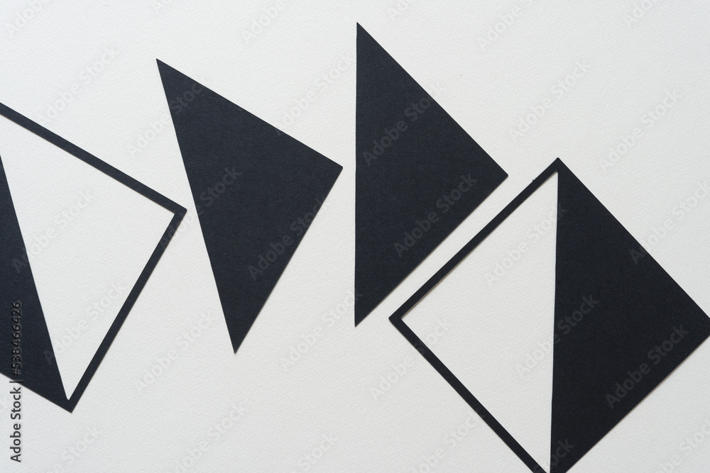 geometric paper shapes (triangles and squares) on blank paper