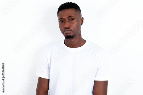 young handsome man wearing white T-shirt over white background crying desperate and depressed with tears on his eyes suffering pain and depression. Sad facial expression and emotion concept.