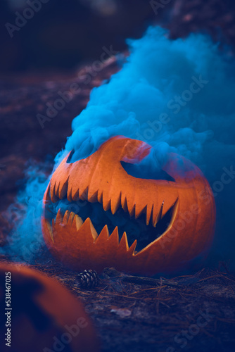 Scary Pumpkin with blue smoke. High quality photo
