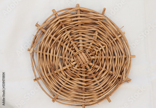 A wicker plate stand is on the table.Part of the interior in boho style.