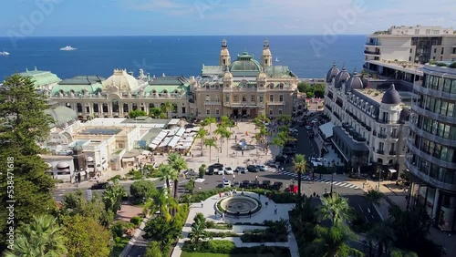 Aerial view of the old casino. area with palm trees. Luxurious super cars in front of the hotel. Monument and fountain. Modern architecture of the kingdom of MONTE CARLO, MONACO