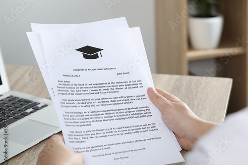 Fényképezés Student with acceptance letters from universities at wooden table indoors, close