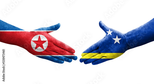 Handshake between Curacao and North Korea flags painted on hands, isolated transparent image.