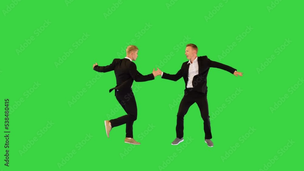 Two nice male dancers perform synchronous dance on a Green Screen, Chroma Key. Two nice male dancers perform synchronous dance on a Green Screen, Chroma Key.