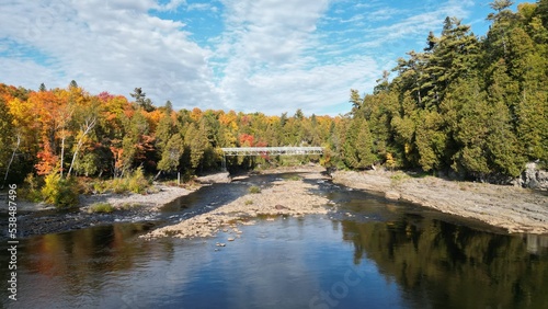Pont au dessus d'une rivière de forêt à l'automne au Canada