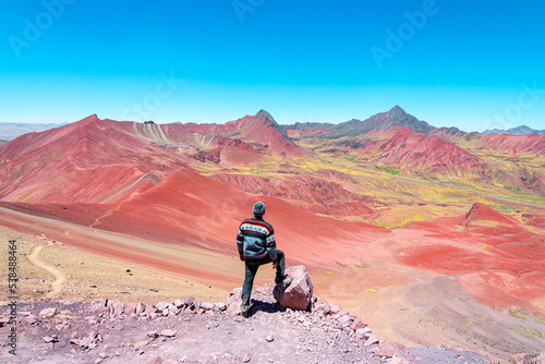 a man is taking a photo in rainbow mountain, peru photo