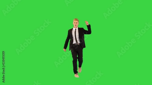 Witty guy in black office suit performs funny dance and sits on a twine in the end on a Green Screen, Chroma Key.