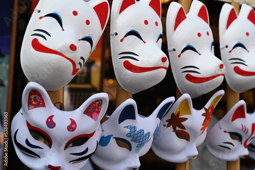 日本のお祭りで狐と猫のお面が並ぶ風景