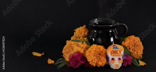 Banner de ofrenda para el día de muertos con flores y calaverita de azucar en fondo negro.  photo