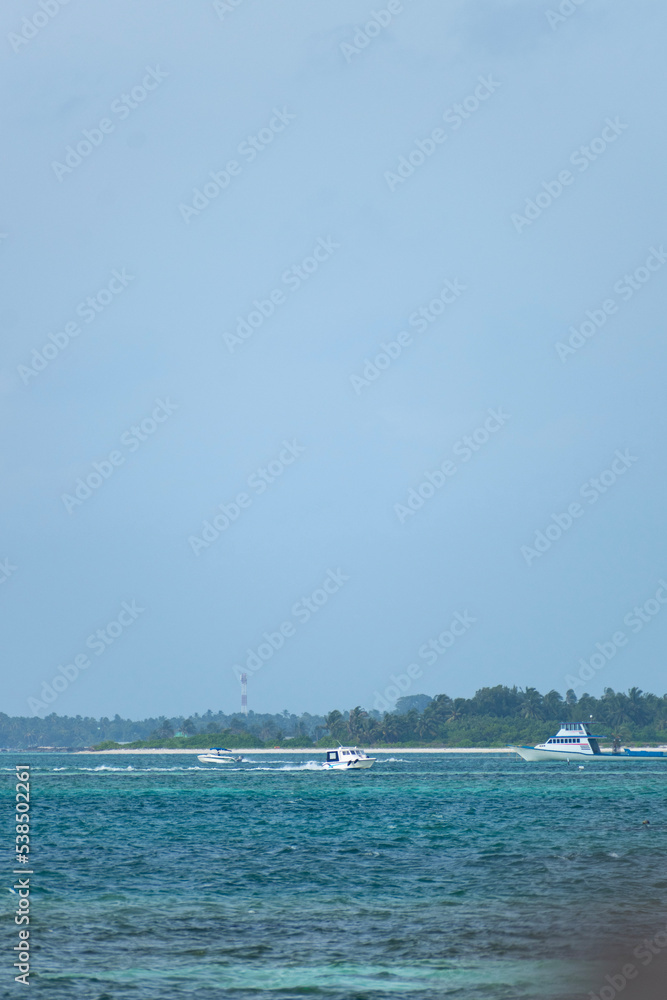 A picture of a speed boat moving towards a cruise boat in the blue sea