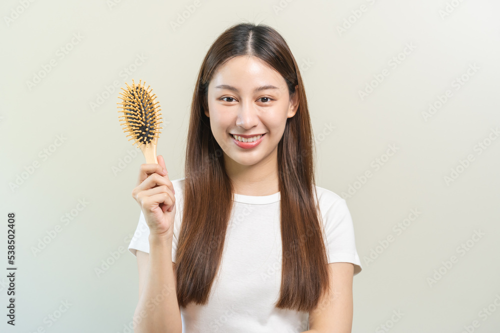 Health hair care, smile beautiful asian woman hand in holding hairbrush and brushing, combing her long straight hair in the morning routine after salon treatment, hairstyle. Isolated on background. Health hair care, smile beautiful asian woman hand in holding hairbrush and brushing, combing her long straight hair in the morning routine after salon treatment, hairstyle. Isolated on background.
