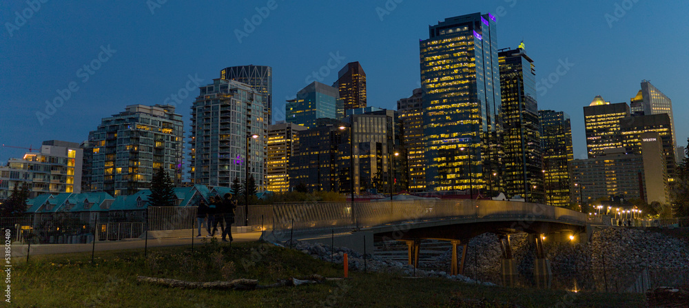 Calgary's cityscape reflected in the river water at dusk.