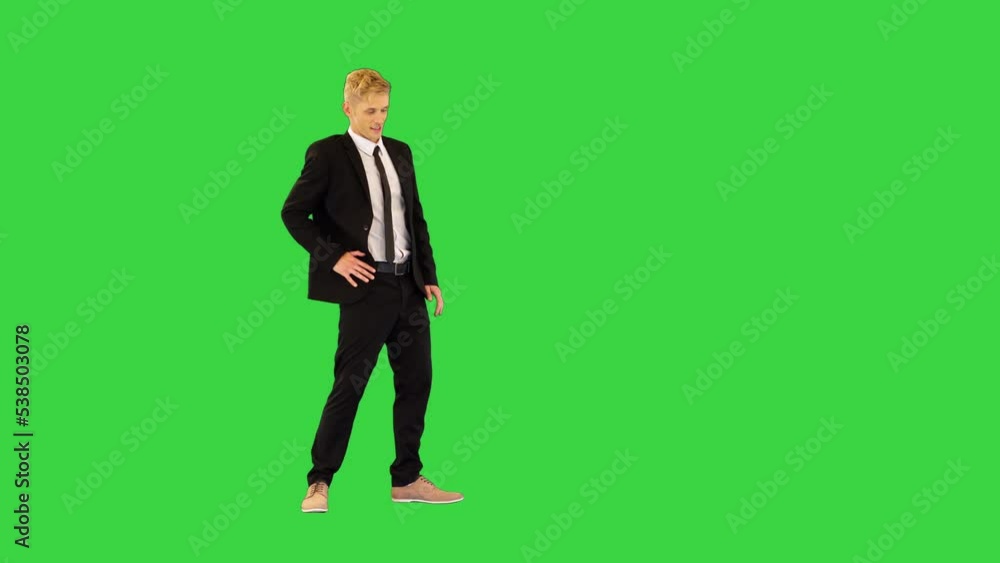 Male dancer in elegant suit makes some robotic dance moves and walks slowly on a Green Screen, Chroma Key. Male dancer in elegant suit makes some robotic dance moves and walks slowly on a Green Screen, Chroma Key.
