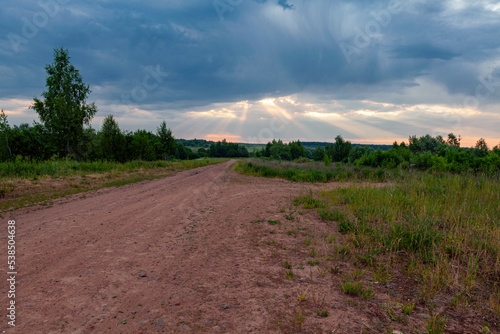 Panoramic shot of a country road leading into the dawn sky