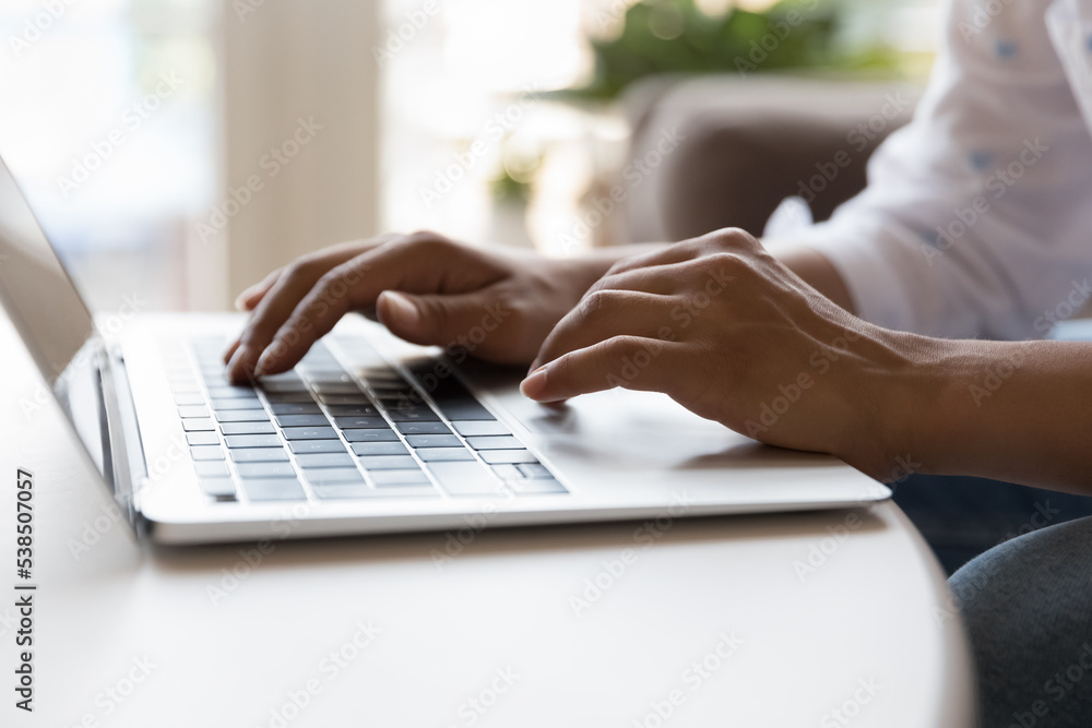 Close up view unknown female hands on laptop keyboard. Unrecognizable female use wireless computer seated at table at home, typing message, e-mailing by work, browsing social media, busy in telework Close up view unknown female hands on laptop keyboard. Unrecognizable female use wireless computer seated at table at home, typing message, e-mailing by work, browsing social media, busy in telework