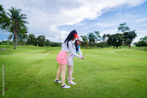 Professional golfer under training golf lesson to young golfer how to play in best way is sport friendship concept.