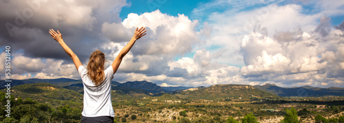 Woman with arms raised, enjoying panoramic cevennes mountain landscape photo