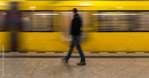 A man in front of the yellow incoming subway