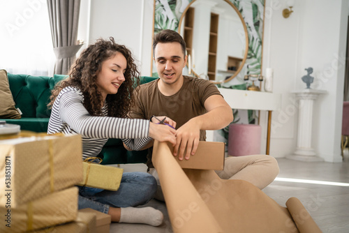 young couple man and woman pack and prepare gifts and presents at home