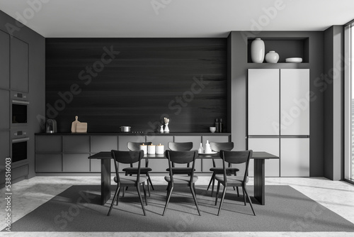 Stylish kitchen interior with dining table and seats, kitchenware and window © ImageFlow