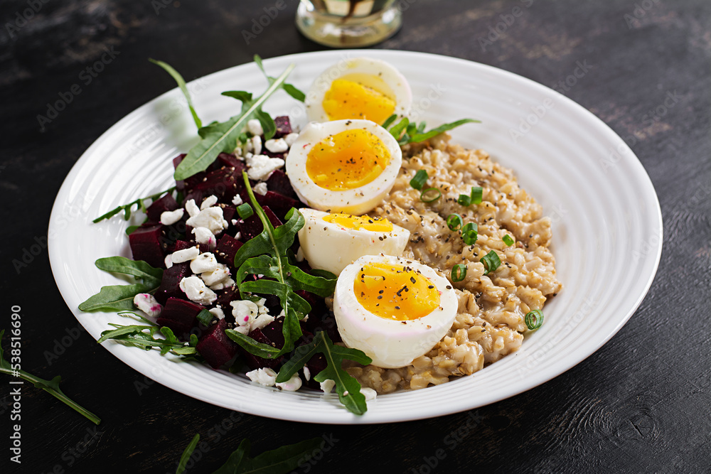 Breakfast oatmeal porridge with boiled eggs, beetroot and green herbs. Healthy balanced food. Breakfast oatmeal porridge with boiled eggs, beetroot and green herbs. Healthy balanced food.