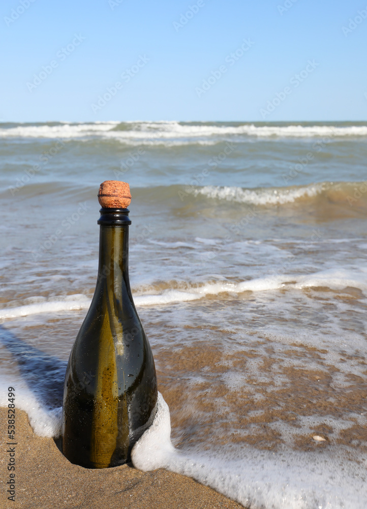 closed bottle with cork beached by the sea closed bottle with cork beached by the sea