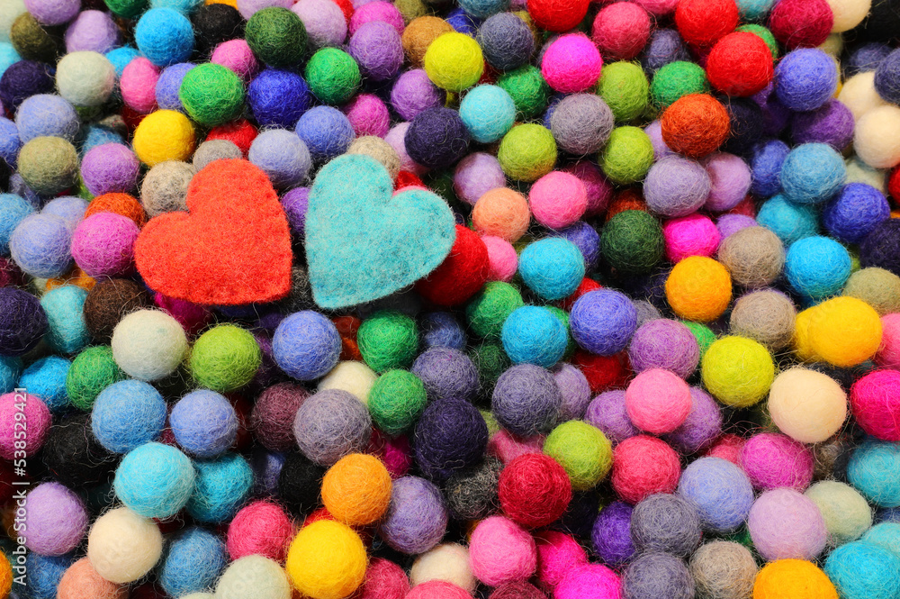 Background of balls of carved wool and two blue and red hearts Background of balls of carved wool and two blue and red hearts