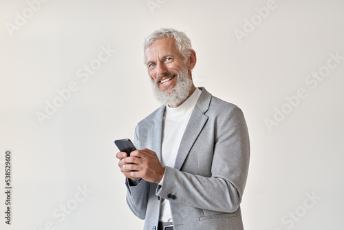 Happy old business man smiling senior mature older businessman professional wearing suit holding cell phone using smartphone mobile app online standing isolated on white background looking at camera. © insta_photos