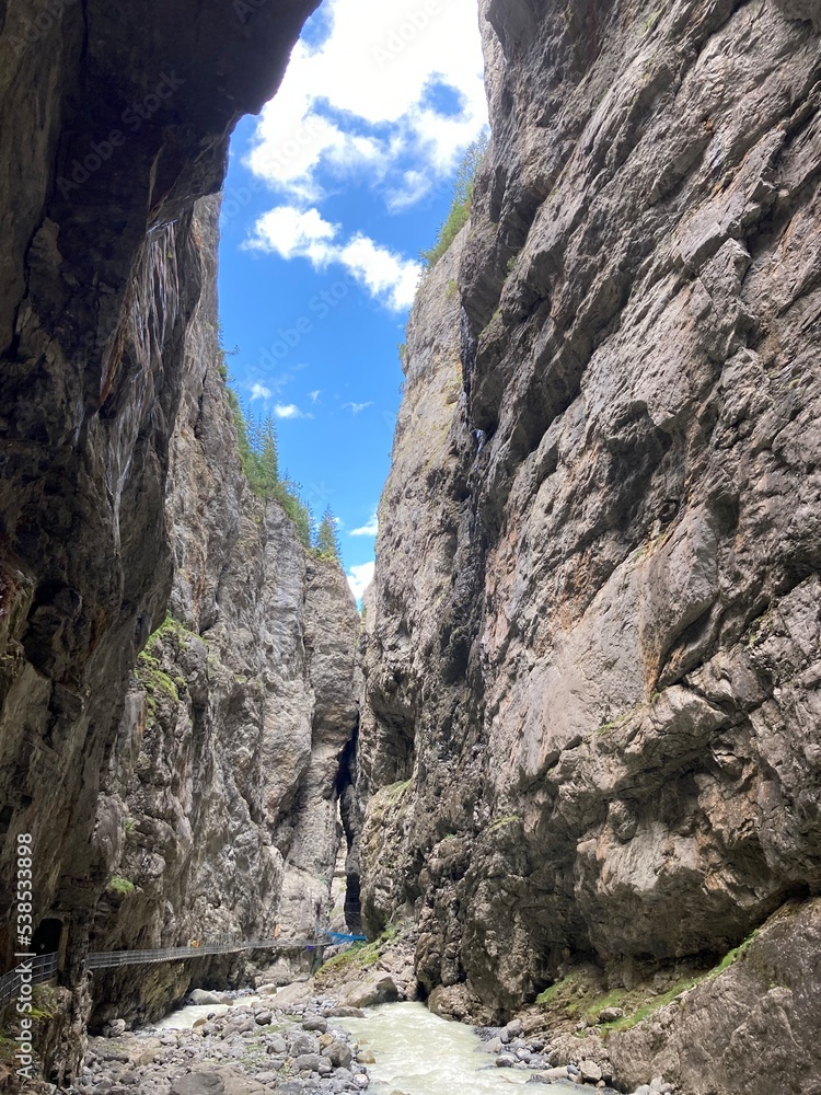 Rocky canyon in the Switzerland. Big rocks and boulders in the canyon. Summer day with blue sky canyon with green forest on the top. Huge canyon with river and waterfalls inside.
Rocky canyon in the Switzerland. Big rocks and boulders in the canyon. Summer day with blue sky canyon with green forest on the top. Huge canyon with river and waterfalls inside.