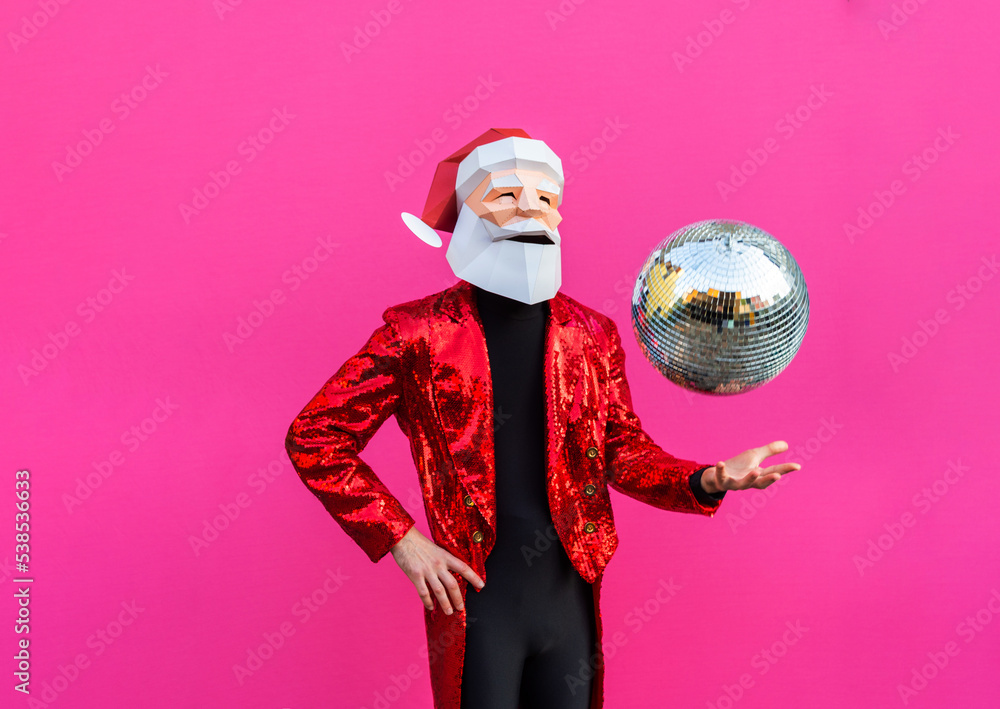 Fototapeta premium Man with funny Santa Claus low poly origami mask on colored background, colorful costume for Christmas holiday