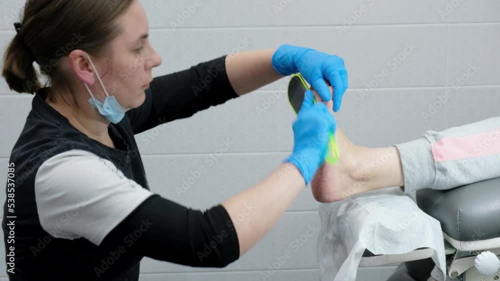 Peeling feet pedicure procedure in a beauty salon for adult woman